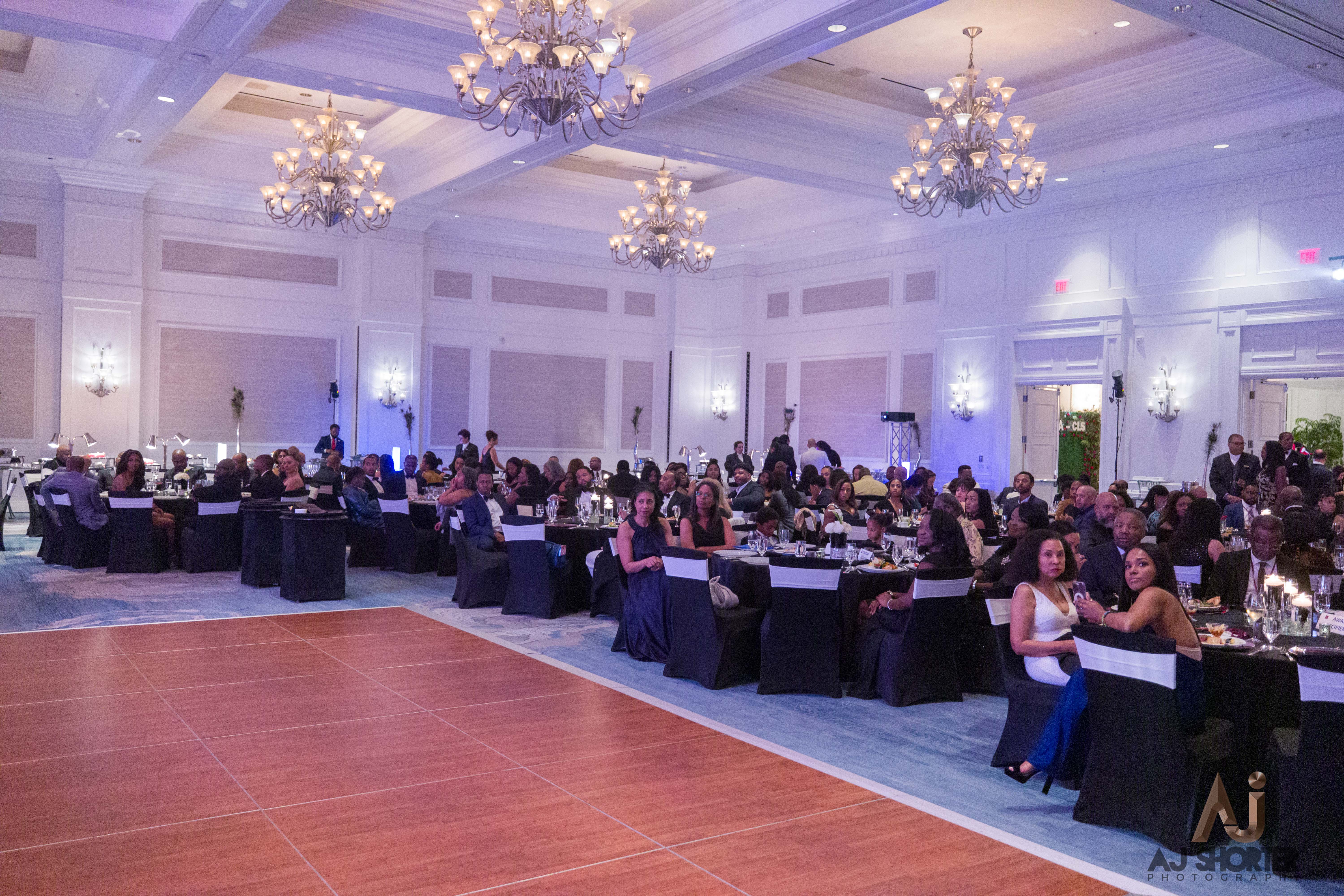 Emmanuella Saforo Jean-Marie Sylla, Jr. Legacy Award A banquet hall with people sitting around tables