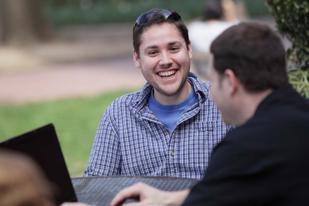 Students talking at a patio table on the quad
