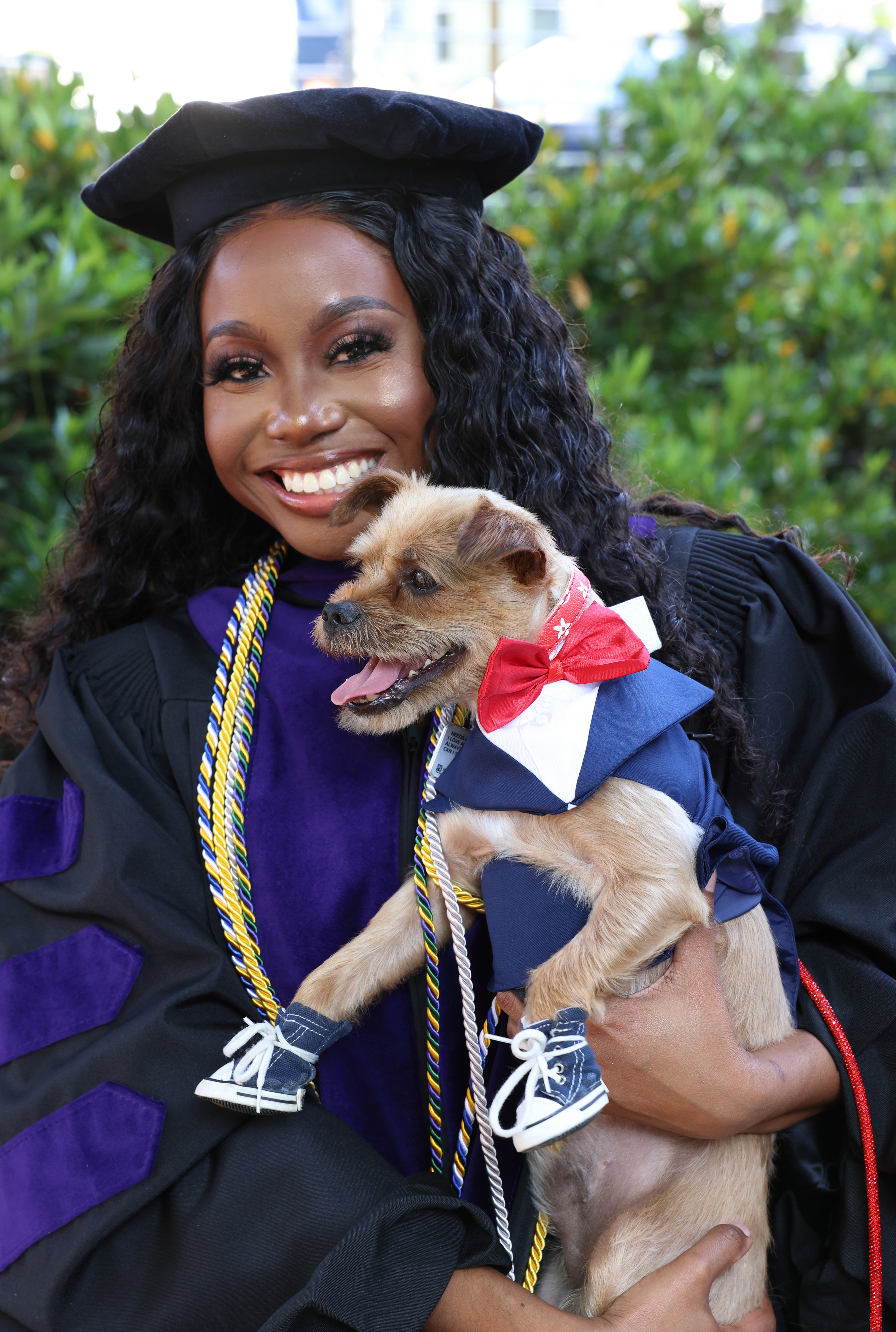 GW Law graduate holding her dog in a suit