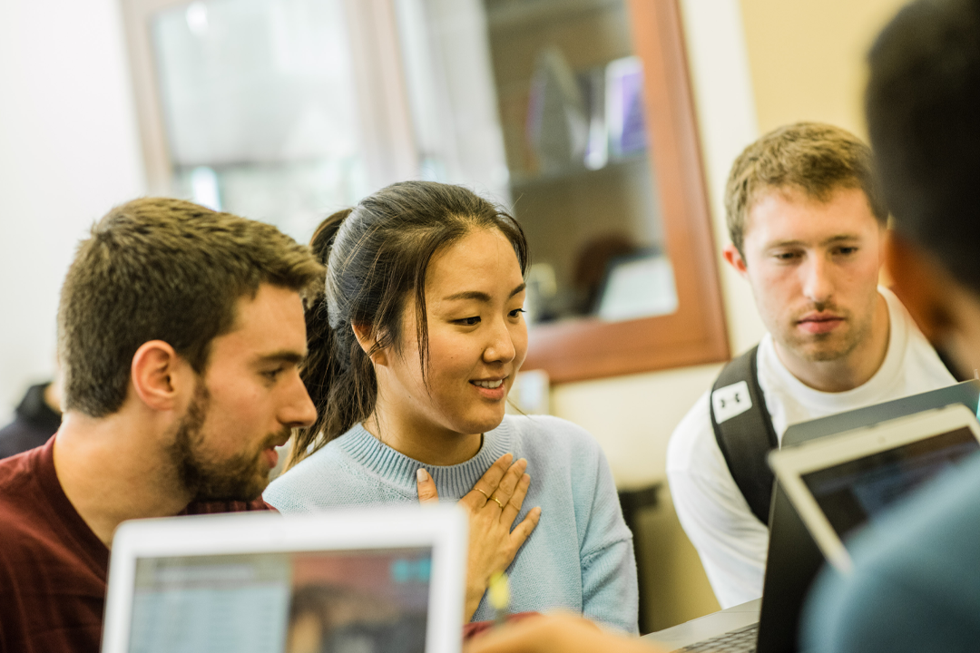 Group of students looking at a computer.