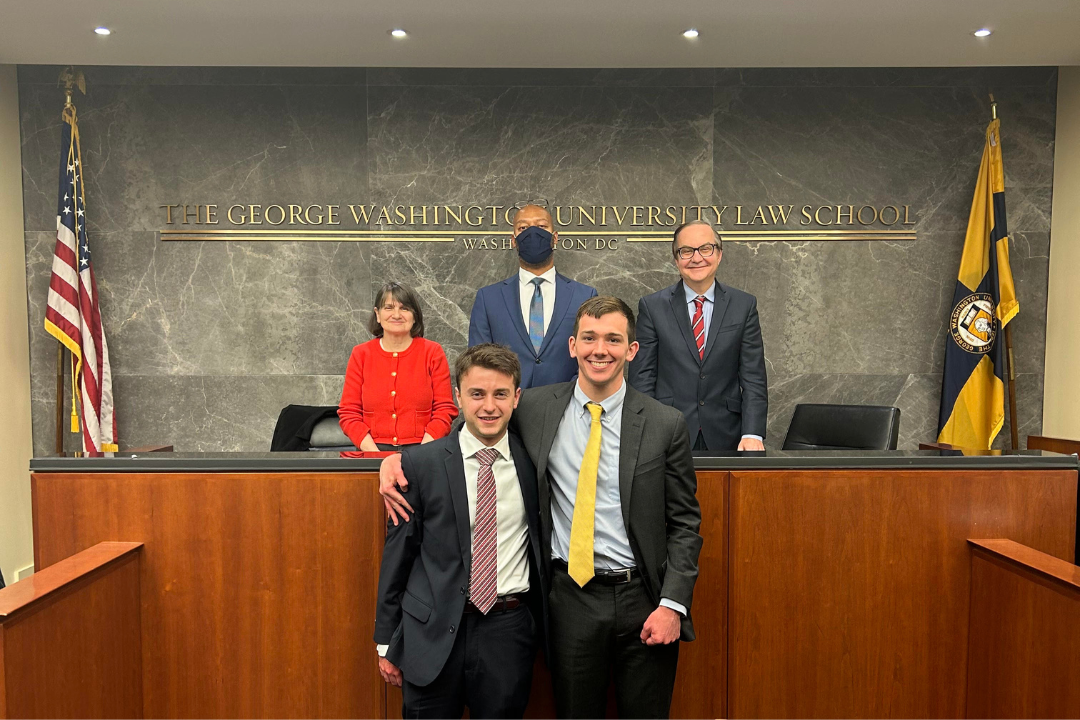 Jane Drummey, Judge Charles Thomas, and Judge Jeffrey Smith on the bench with students Kyle Coopersmith and James Dugan after winning the competition 