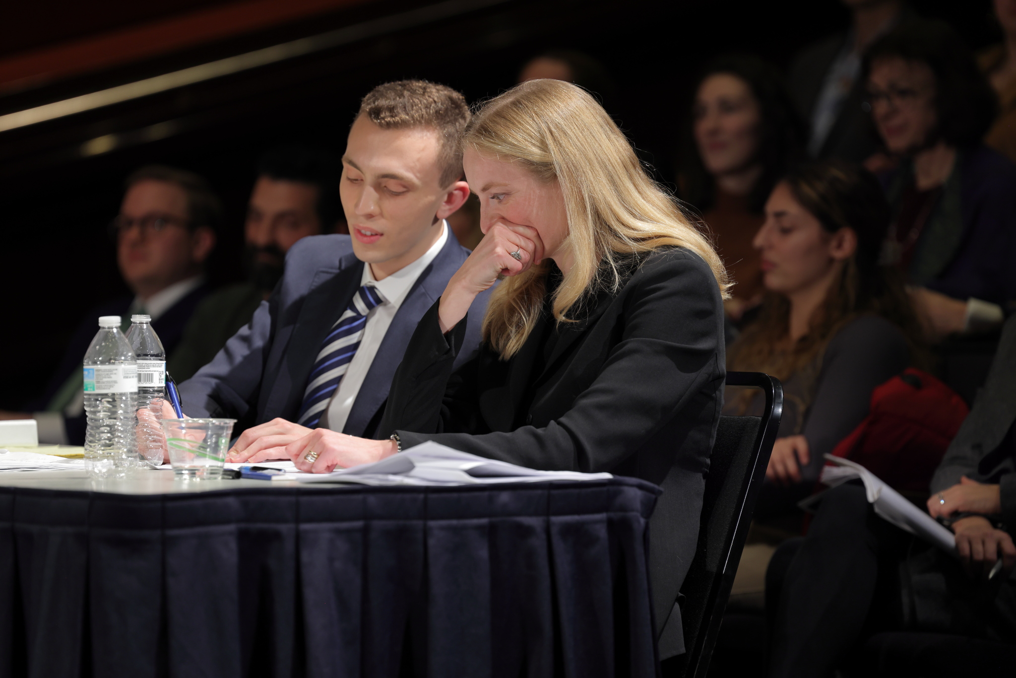Simon Poser and Angela Seeger conferring with each other as their opposition gives their oral arguments