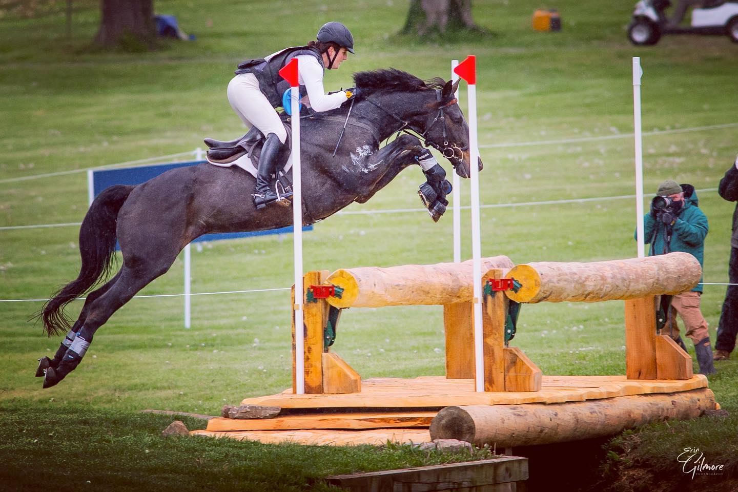 Ema Klugman riding a horse while it's going over poles