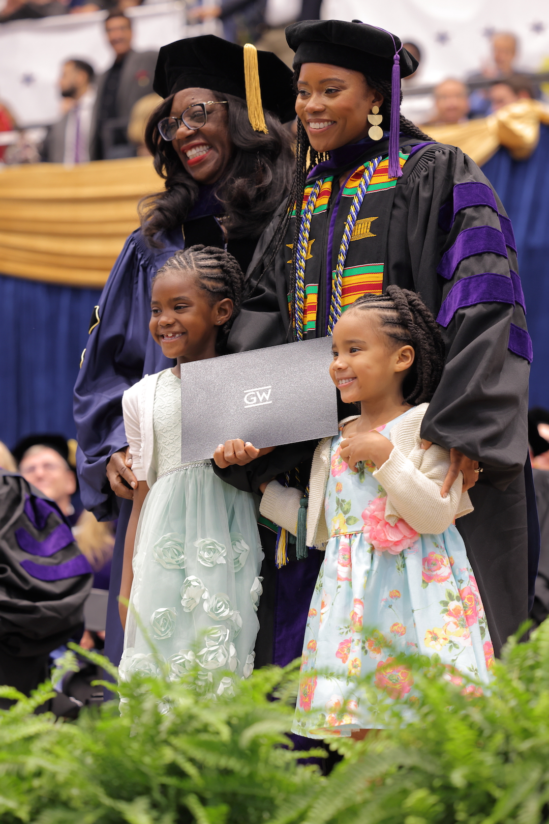 Dean Matthew posing with a law graduate and her two kids