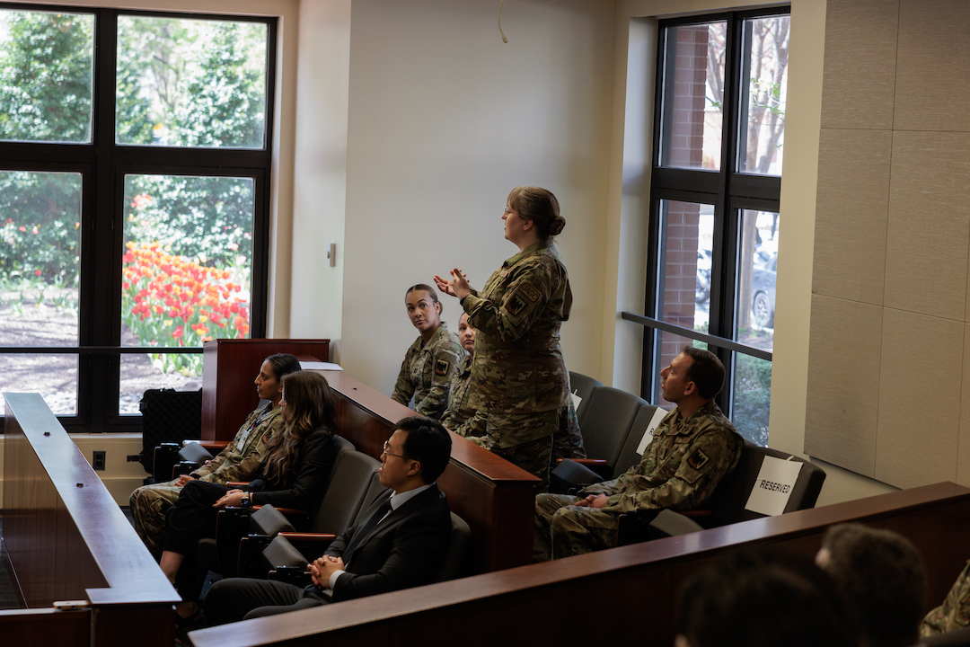 Students in Air Force uniforms with one student standing and talking