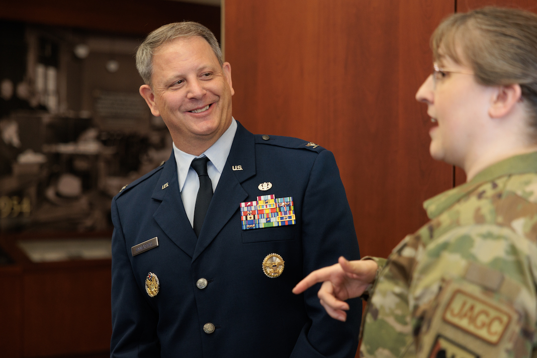 An officer smiling and talking to a student in an Air Force uniform