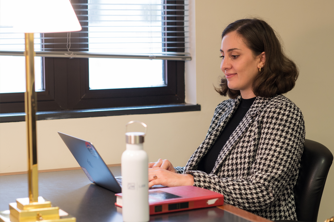 Female student sitting at a table working on her laptop.