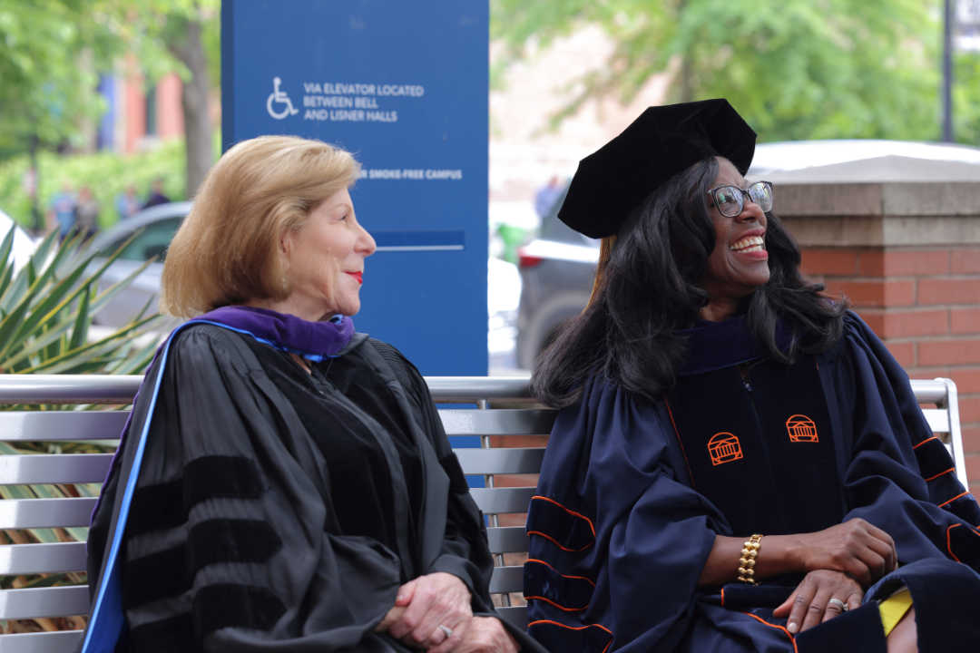 Nina Totenberg and Dean Dayna Bowen Matthew sitting on a bench and smiling