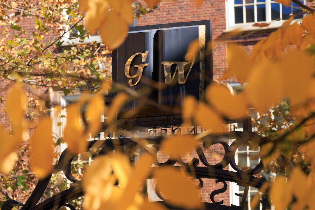 GW Professors Gate with fall leaves in the foreground