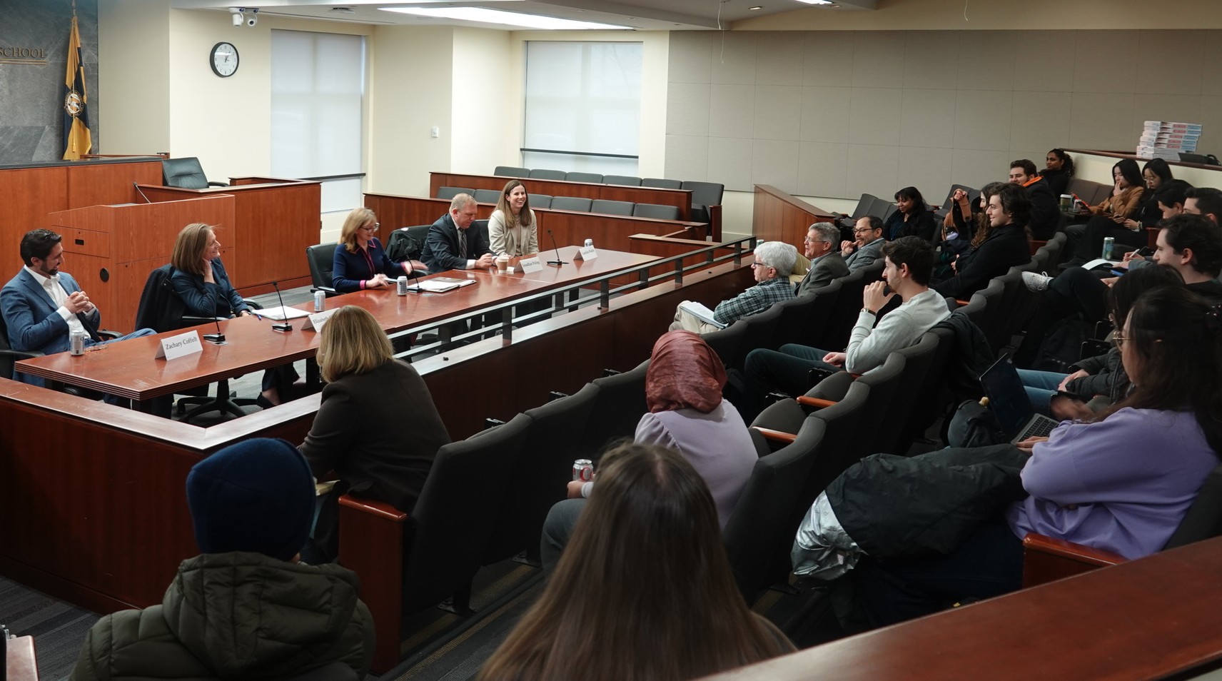 Students listen to a panel of professors in the Burns Moot Court Room.