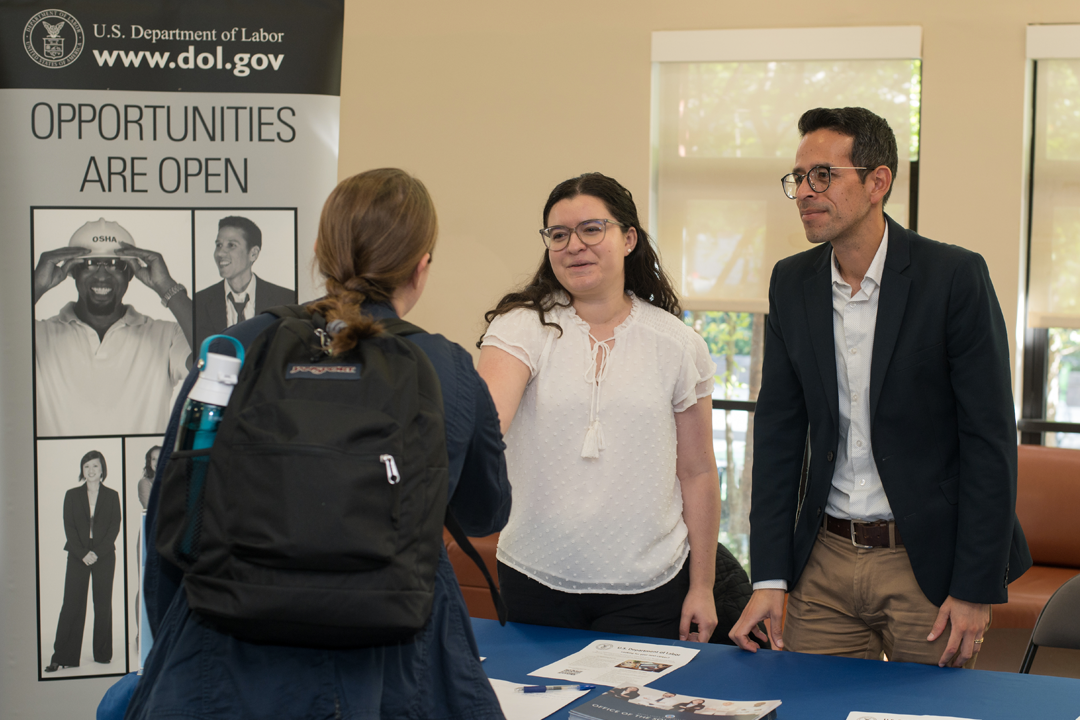 A student shaking hands with a representative for the U.S. Department of Labor.
