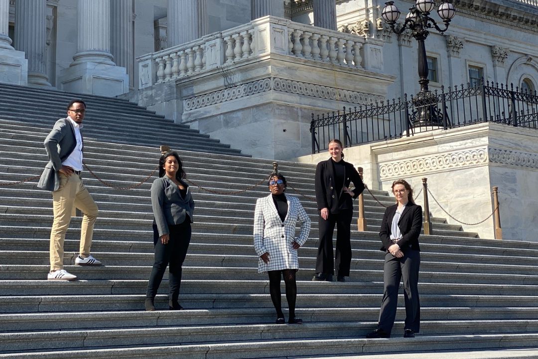 GW Law students stand on the steps at the U.S. Capitol.