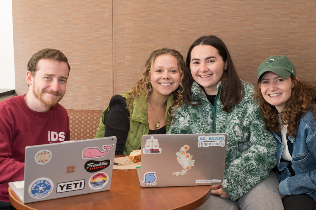 Four law students sitting in a lounge working on their laptops.