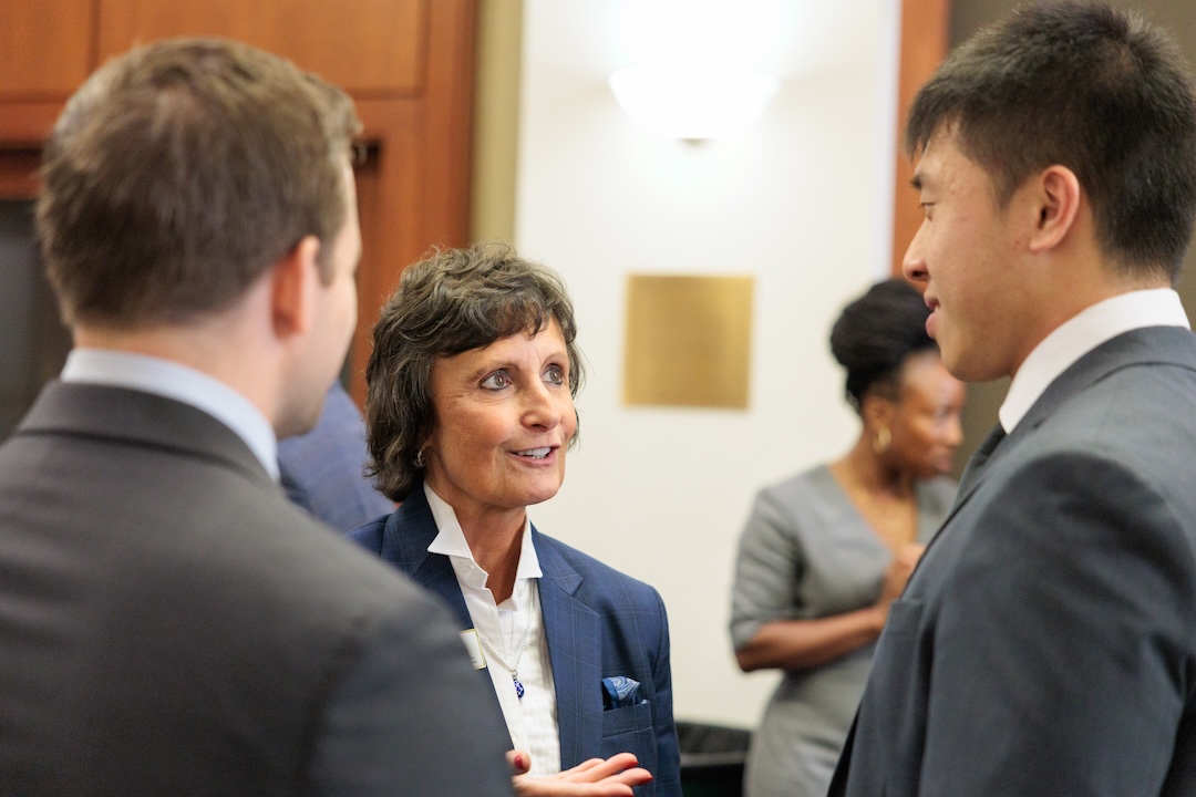 Two men and a woman speak to each other at the law school during the Veterans welcome back reception