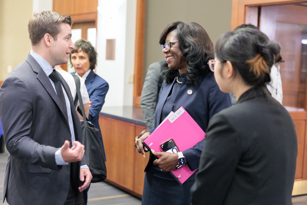Two students talk to Dean Dayna Bowen Matthew during the veterans welcome back reception