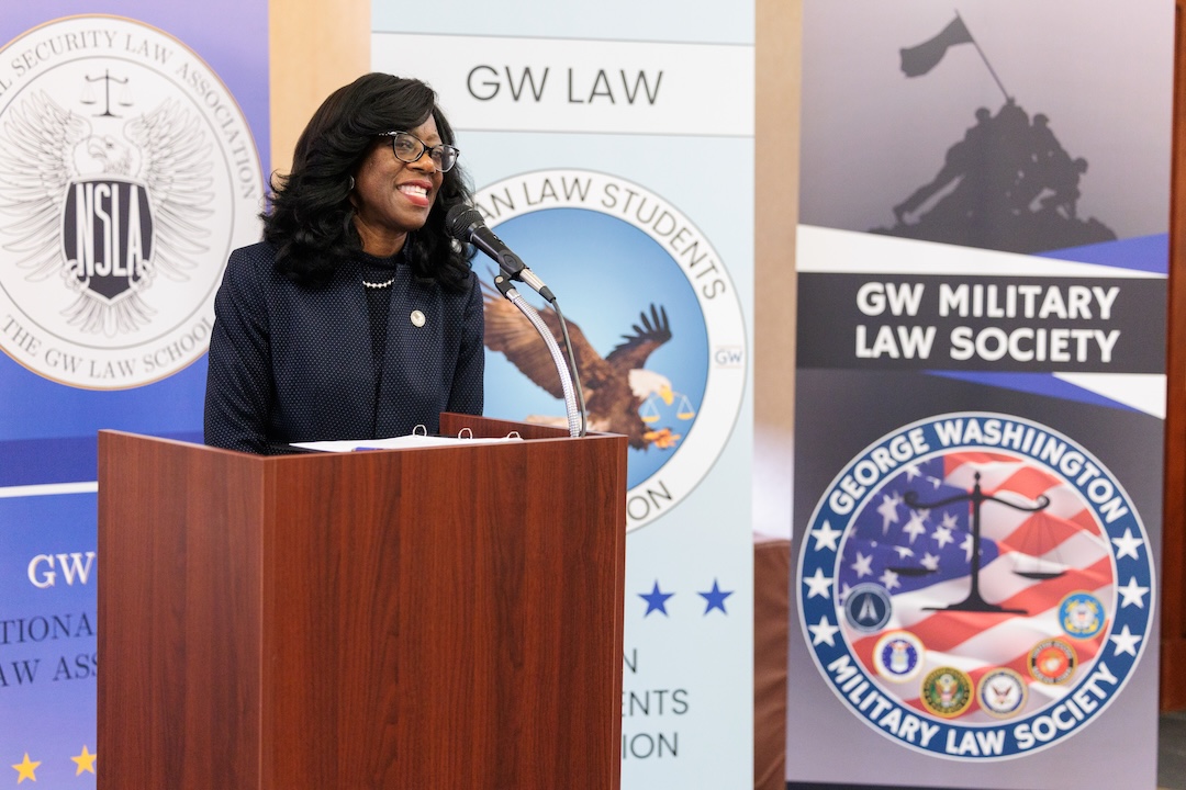 GW Law Dean Dayna Bowen Matthew speaks behind a podium during the 2025 Veterans welcome back reception