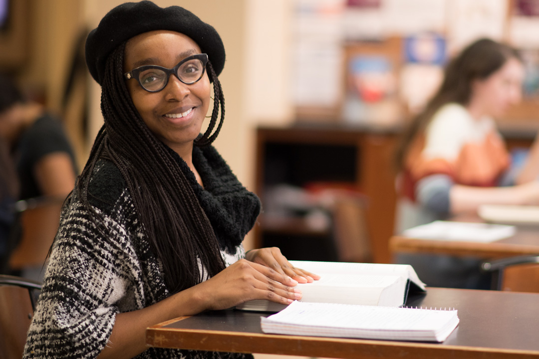 A student looking at a textbook in the library.