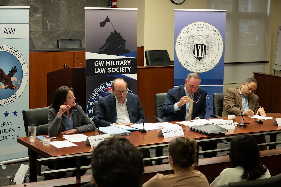 GW Law Professor Laura Dickinson, Robert Taylor, Charles Pede, and Professor Jonathan Cedarbaum sit on a panel in the burns moot court room.