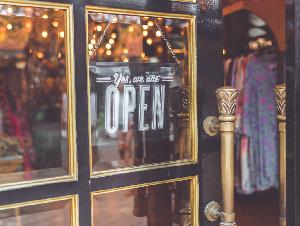 Store front with "Yes, We're Open" sign on door