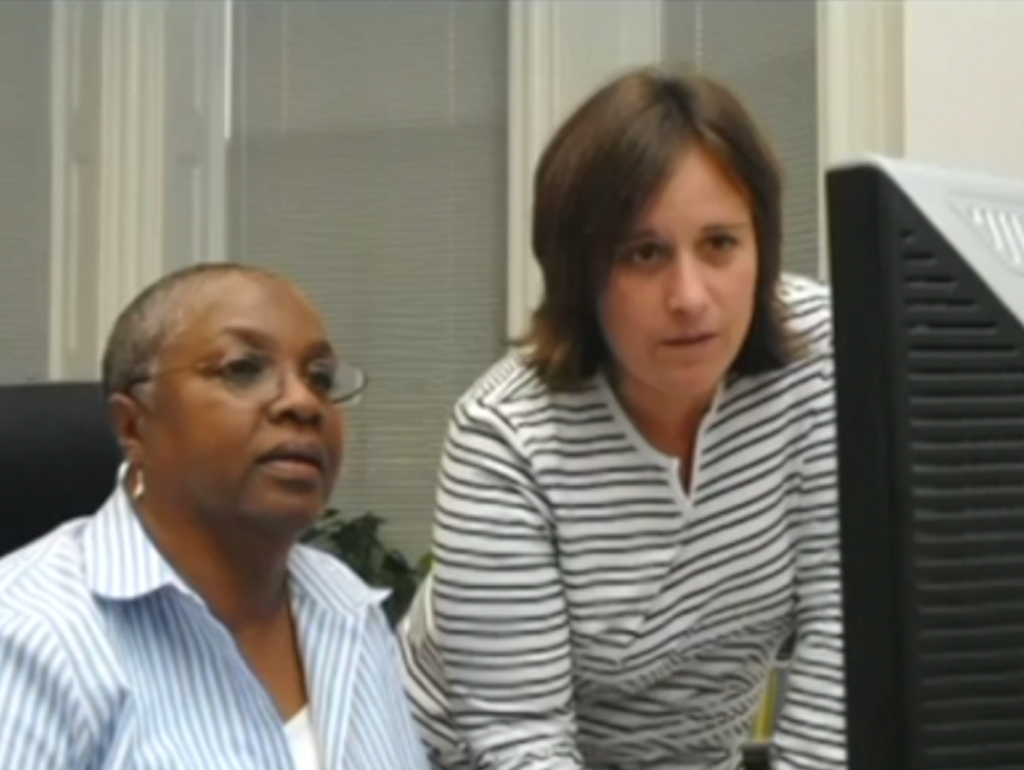 Milagros and co-worker both looking at a computer screen