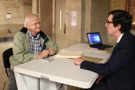 Thomas Lodwick, JD '13, sits with a client in the county courthouse.