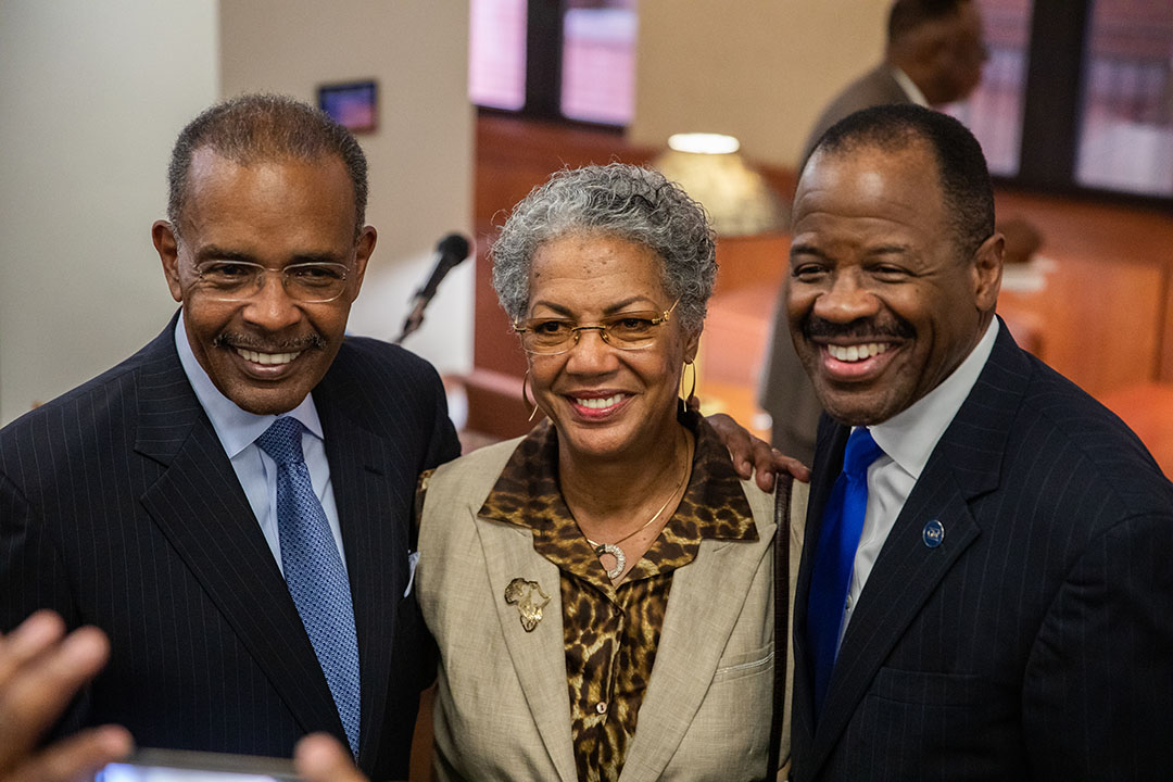 Dean Morant stands with two friends at his portrait unveiling.