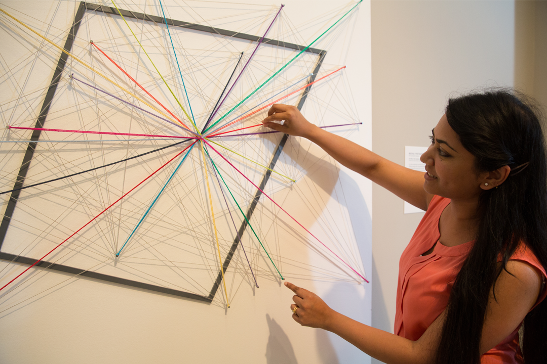 Student pointing to yard design on a wall