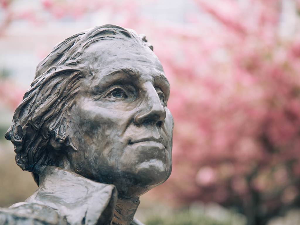GW Statue in front of cherry blossom tree in bloom