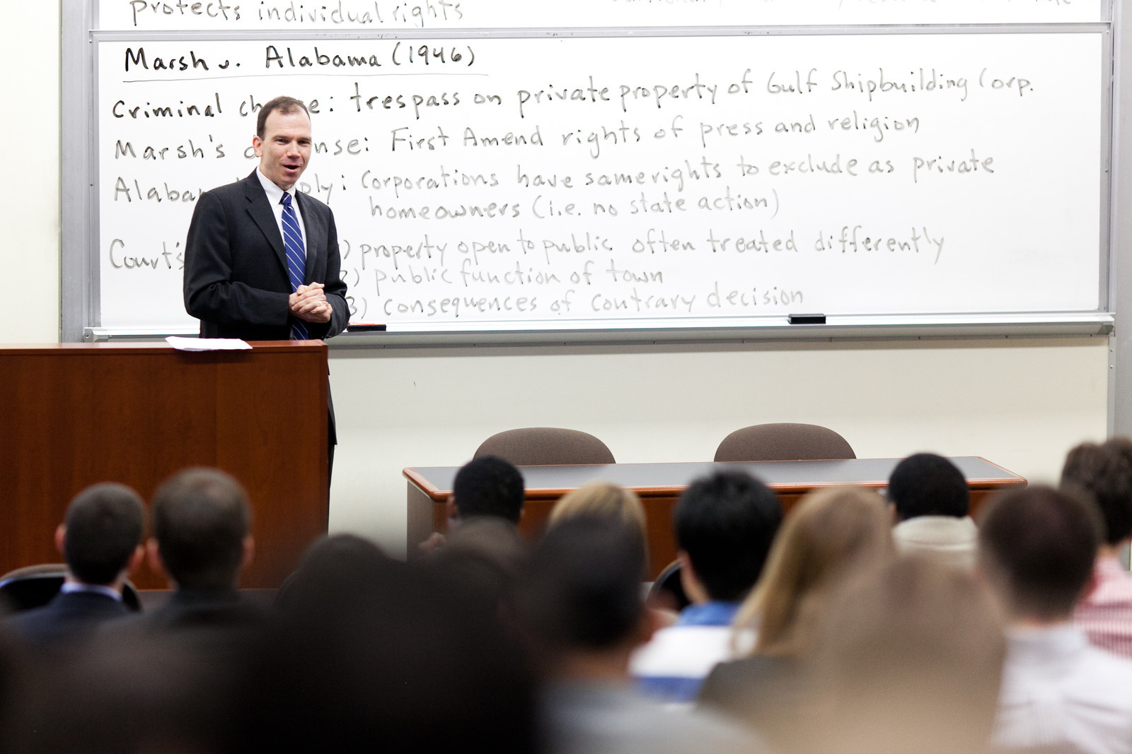 Professor orating in front of whiteboard with notes on Marsh v. Alabama case