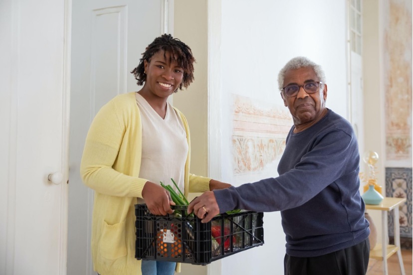 Man handing a woman a box of items