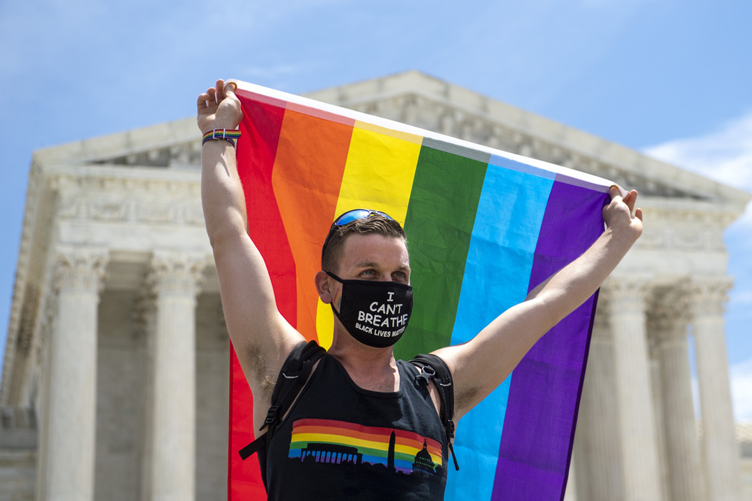 Joseph Fons hold up Pride Flag in front of Supreme Court of United States