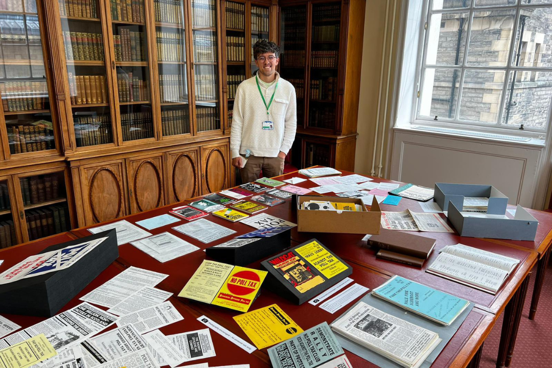 A man standing behind a table with lots of books on it