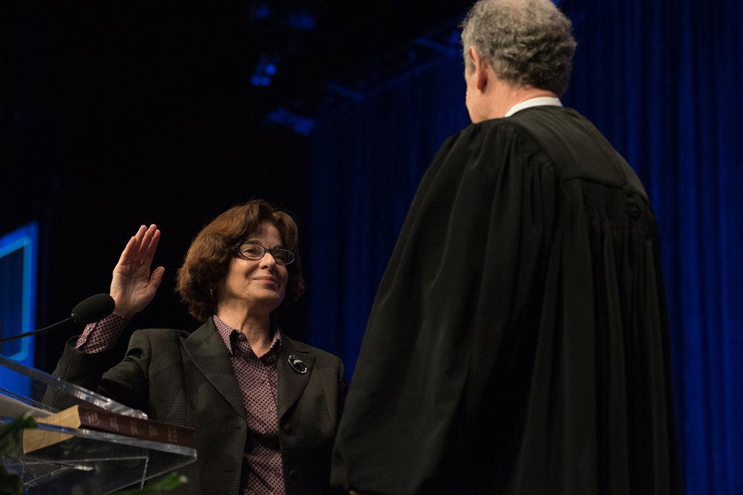 Professor Mary M. Cheh, left, poses with the Honorable Craig S. Iscoe, right, during the swearing-in ceremony.