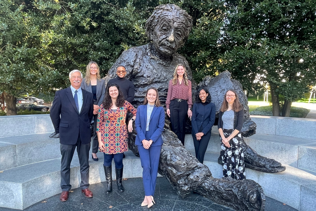 A group of people in front of an Albert Einstein statue