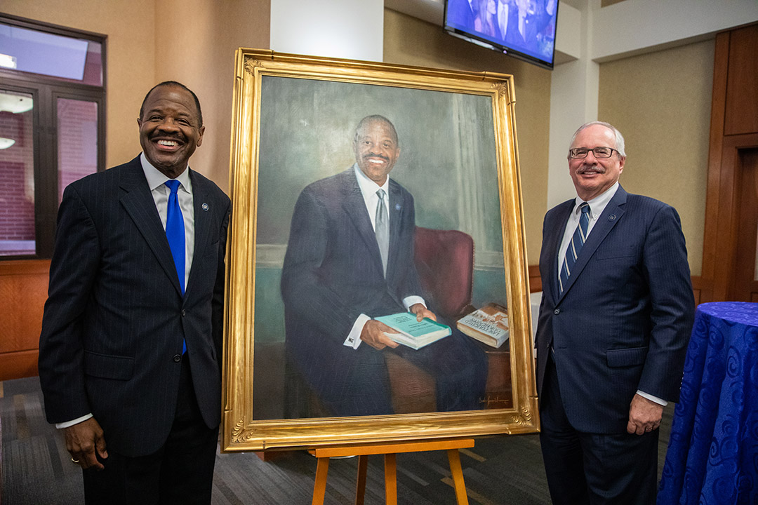 Former GW Law Dean Blake D. Morant and GW President Dr. Thomas J. LeBlanc stand beside a portrait of Mr. Morant.