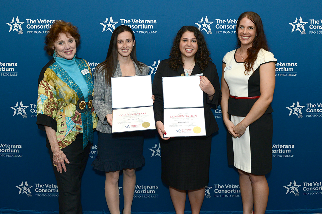 A group of four women stand, holding certificates