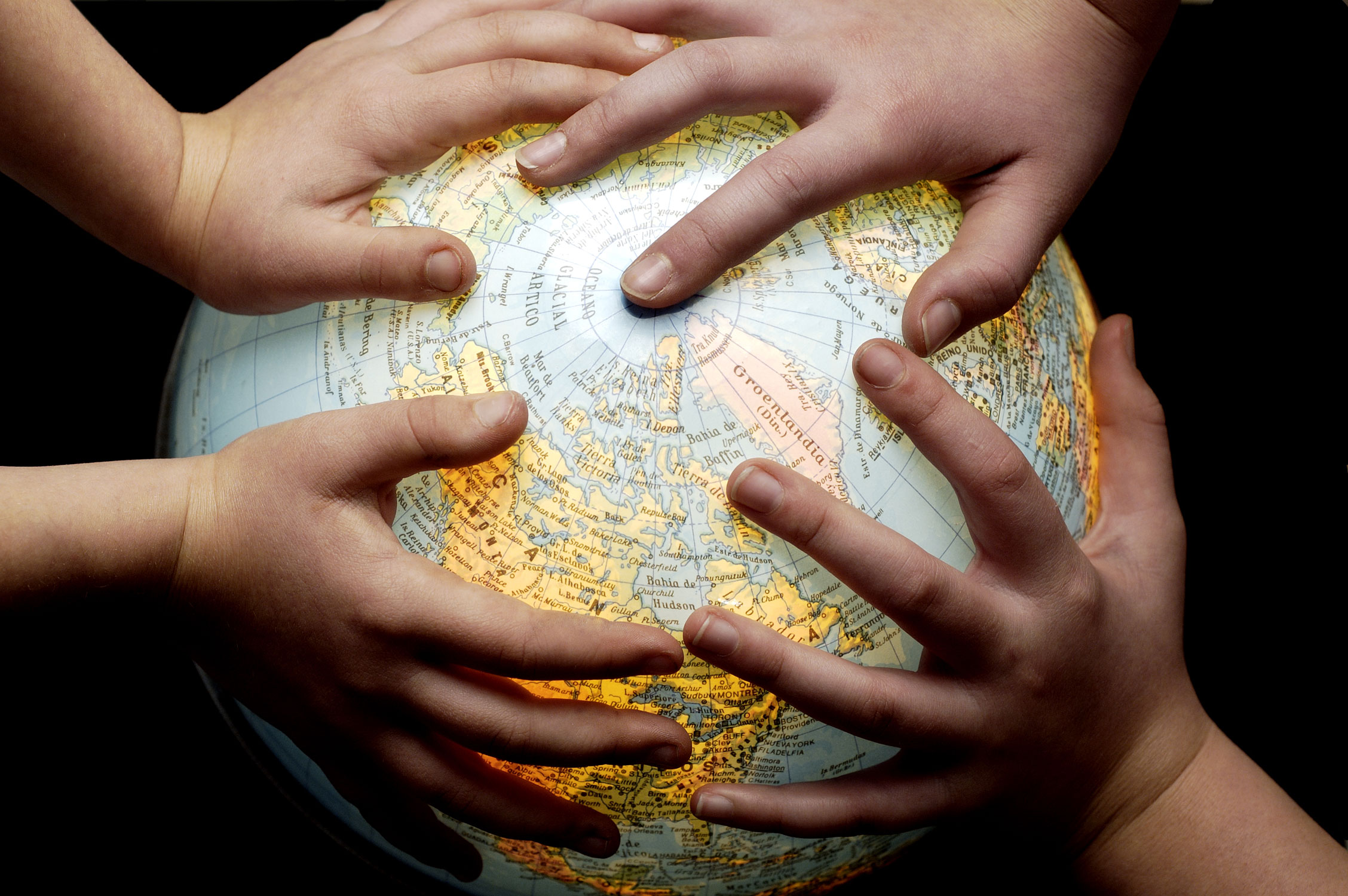 Photo of hands on a globe
