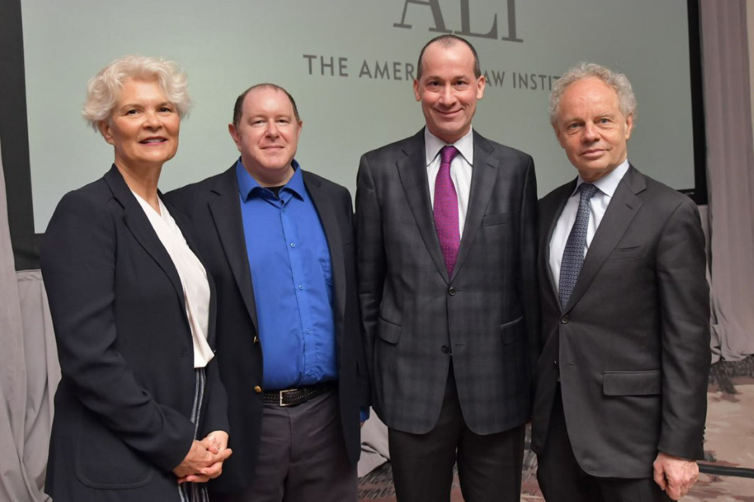 Four people stands together for a photo.