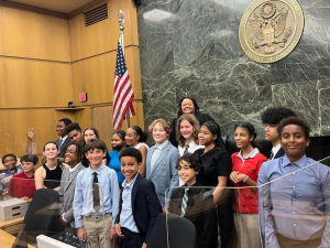 A group of middle schoolers in court behind the judges bench