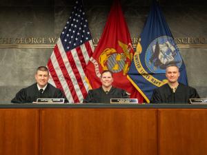 Navy-Marine Corps Court of Criminal Appeals Judges (Colonel) Alison Daly, (Captain) Nathaniel Gross, and (Lieutenant Colonel) Keaton Harrell sit in the judges bench in Burns Moot Court Room.