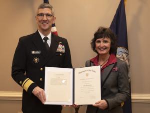 Associate Dean Lisa M. Schenck receives an award from Rear Admiral (Upper Half) Jay Bynum. 