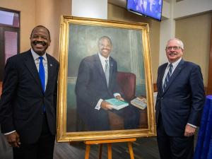 Former GW Law Dean Blake D. Morant and GW President Dr. Thomas J. LeBlanc stand beside a portrait of Mr. Morant.