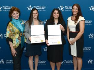A group of four women stand, holding certificates
