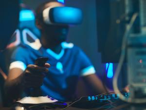 Person playing an esports game with alternate reality glasses in front of a computer.