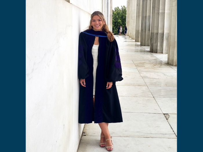 Christina Morgan posing with her graduation robe on