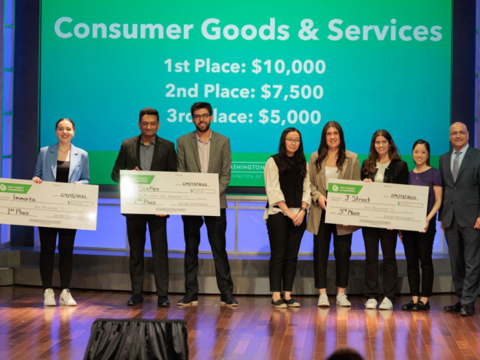 Students holding big checks