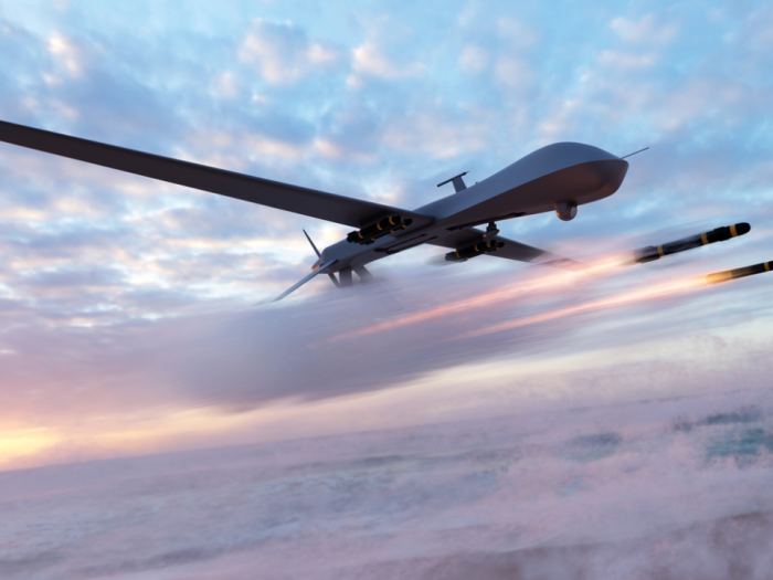 A drone flying in the sky with missiles coming out of it