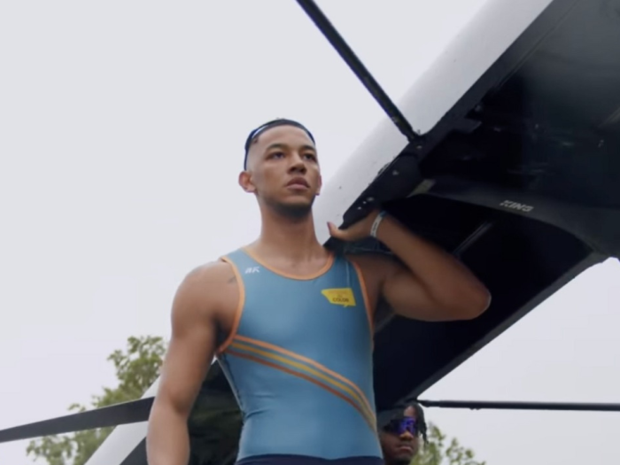 Devin Woodson holding a rowing boat on his shoulder