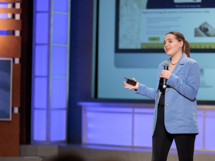Sonia Schmidt presenting on stage talking into a microphone