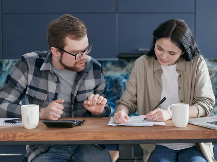 Man and Woman Sitting at Table with Documents